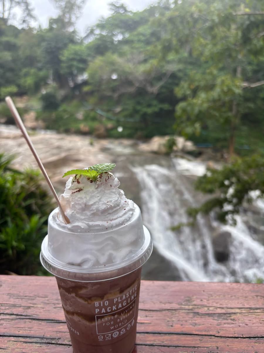 Frappe with whipped cream in front of a waterfall